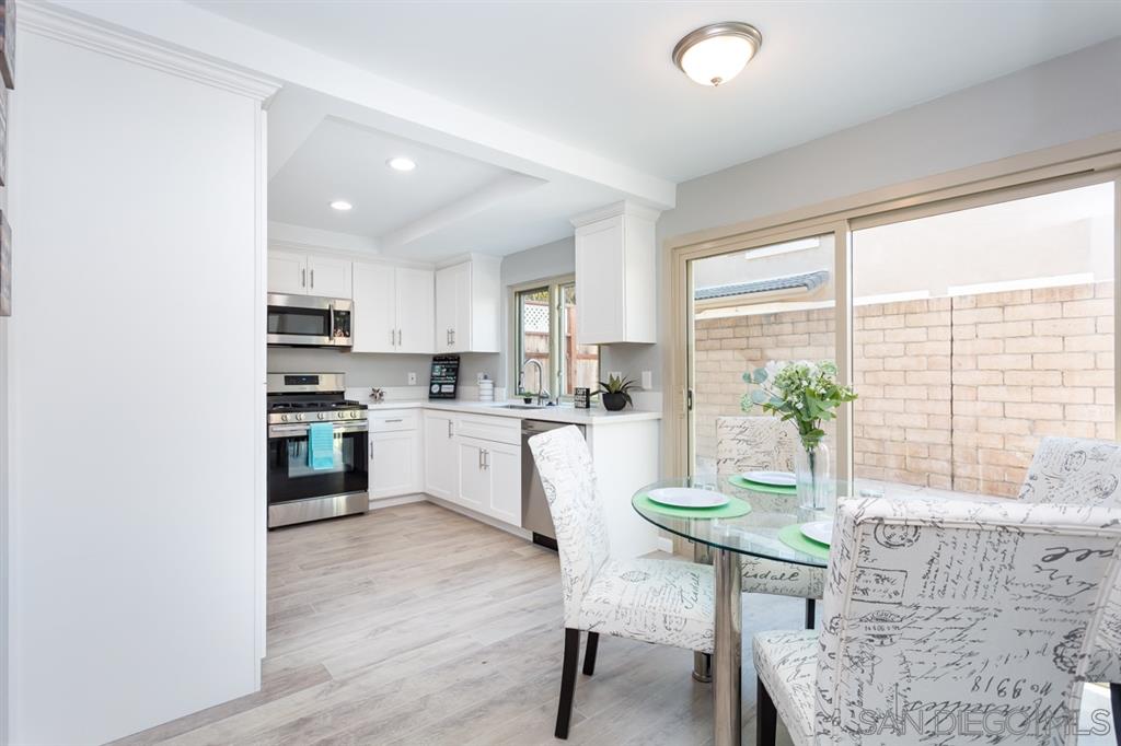 265 Argus Way Oceanside, CA 92057 - Photo 13 of 24 a kitchen with white cabinets and wooden floor