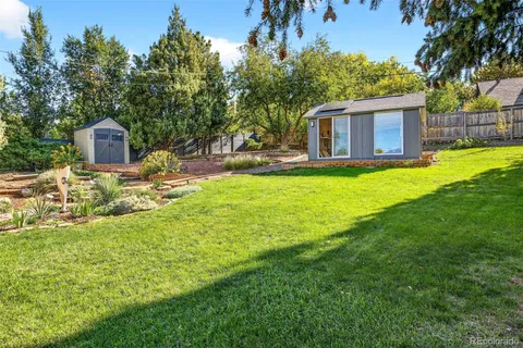 a front view of a house with a garden and tree
