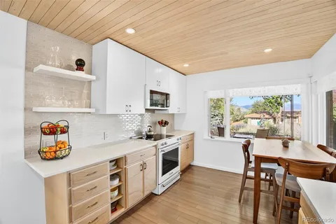 a kitchen with a sink a stove cabinets and wooden floor