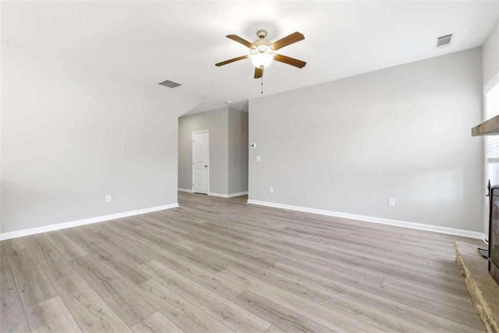 2066 Highway 63 Homer, GA 30547 - Photo 11 of 65 an empty room with wooden floor and ceiling fan