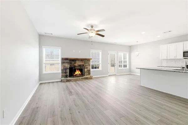 a view of a kitchen with wooden floor and a ceiling fan