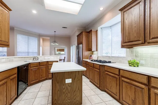 a kitchen with stainless steel appliances granite countertop a sink counter space cabinets and a large window