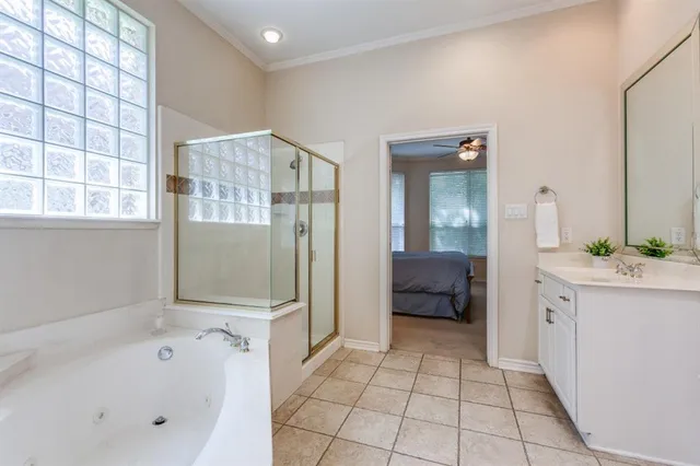 a bathroom with a tub a sink and a large mirror
