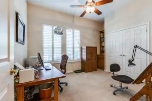 a view of a livingroom with workspace and a window
