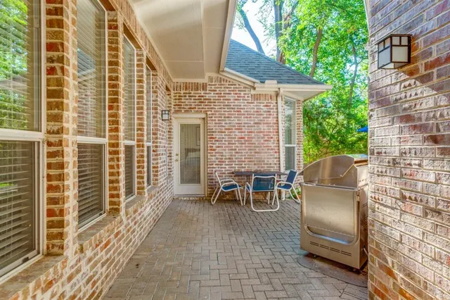 a view of a patio with table and chairs with wooden floor and fence