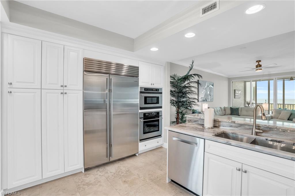 265 Indies Way, Unit 1404 Naples, FL 34110 - Photo 13 of 43 a kitchen with refrigerator and cabinets
