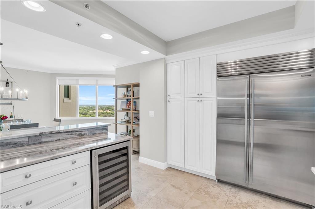 265 Indies Way, Unit 1404 Naples, FL 34110 - Photo 14 of 43 a kitchen with granite countertop a refrigerator and cabinets