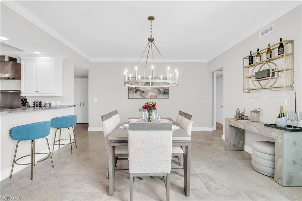265 Indies Way, Unit 1404 Naples, FL 34110 - Photo 16 of 43 a view of a dining room with furniture and chandelier