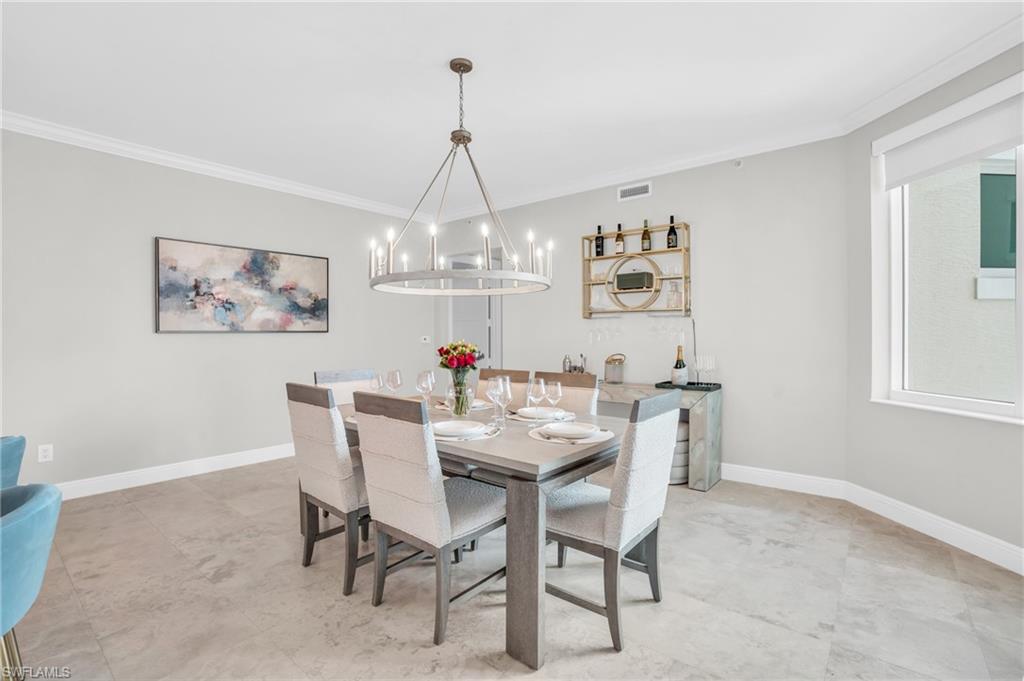 265 Indies Way, Unit 1404 Naples, FL 34110 - Photo 17 of 43 a view of a dining room with furniture a chandelier and wooden floor
