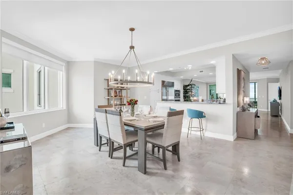 a view of a dining room and livingroom with furniture wooden floor a chandelier