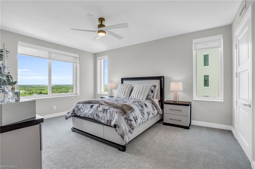 265 Indies Way, Unit 1404 Naples, FL 34110 - Photo 21 of 43 a bed sitting in a spacious bedroom next to a window