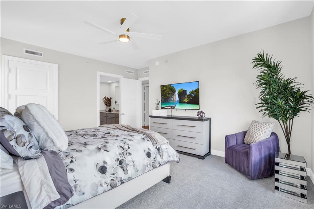 265 Indies Way, Unit 1404 Naples, FL 34110 - Photo 22 of 43 a bedroom with a bed and a flat screen tv