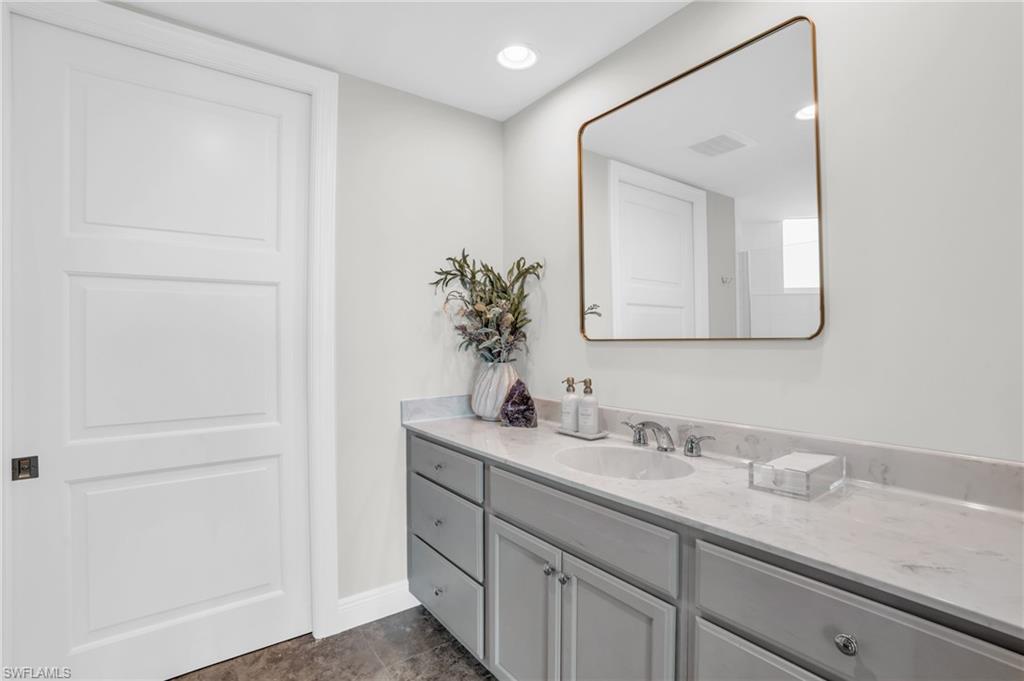 265 Indies Way, Unit 1404 Naples, FL 34110 - Photo 26 of 42 a bathroom with a double vanity sink and a mirror