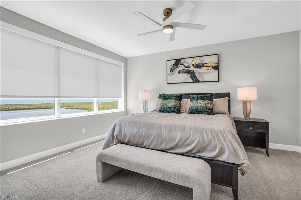265 Indies Way, Unit 1404 Naples, FL 34110 - Photo 29 of 42 a bedroom with a bed and a lamp on table