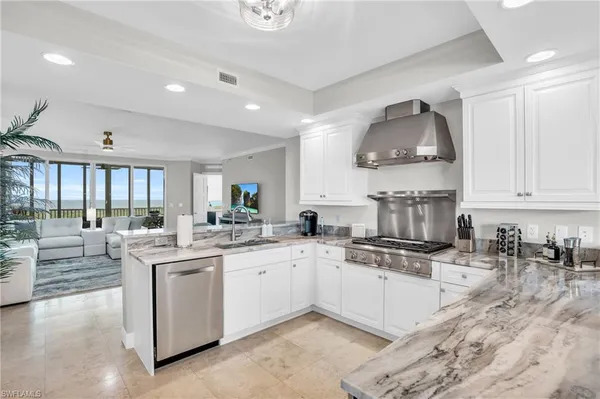 a kitchen with stainless steel appliances a sink a stove and cabinets