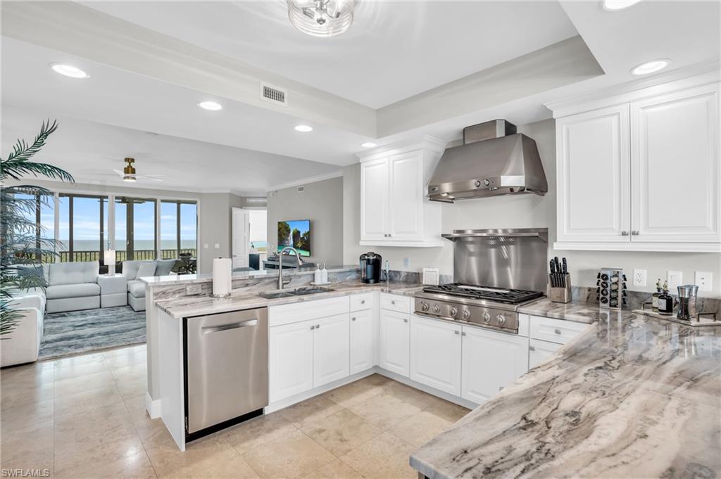 265 Indies Way, Unit 1404 Naples, FL 34110 - Photo 5 of 43 a kitchen with stainless steel appliances a sink a stove and cabinets