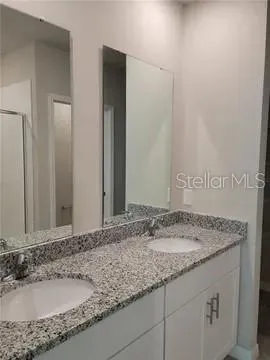 a bathroom with a granite countertop sink and a mirror