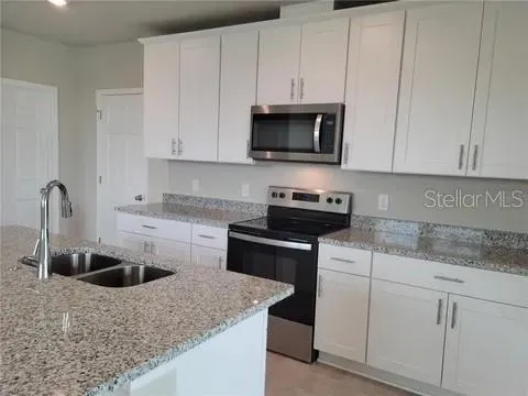 a kitchen with white cabinets sink and stainless steel appliances