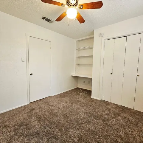 an empty room with windows and cabinet
