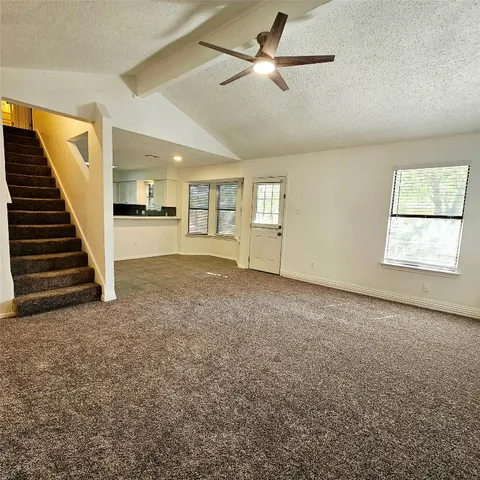 a view of kitchen with stainless steel appliances granite countertop a stove top oven a sink a window and white cabinets