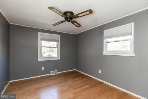 a view of a livingroom with a ceiling fan and wooden floor