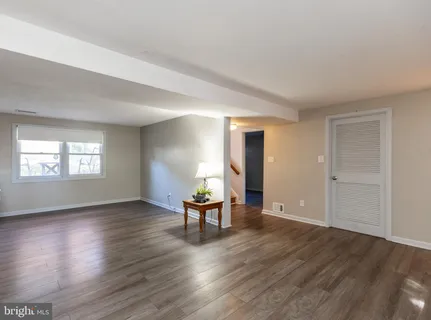 an empty room with wooden floor and a window
