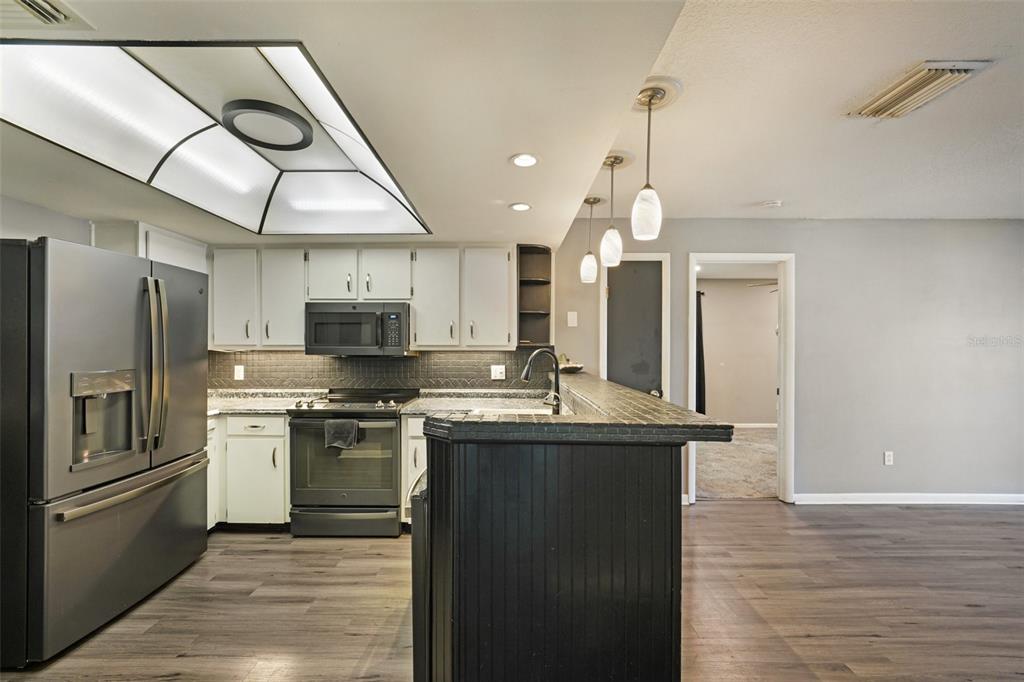 2015 Ronald Circle Seffner, FL 33584 - Photo 8 of 27 a kitchen with stainless steel appliances granite countertop a sink a stove and a refrigerator