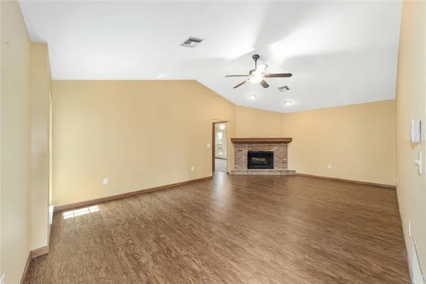 wooden floor in an empty room with a ceiling fan