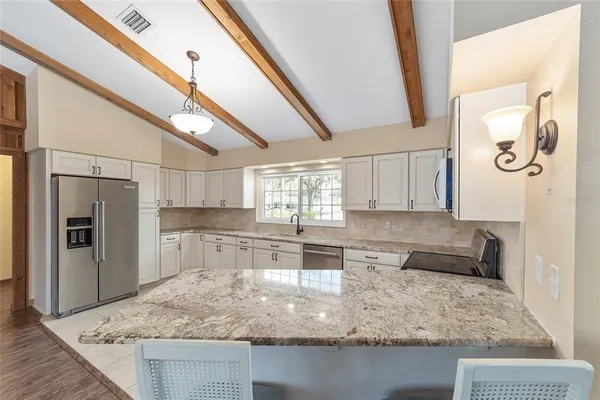 a kitchen with stainless steel appliances granite countertop a sink stove and refrigerator