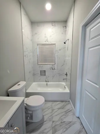 a bathroom with a toilet a sink and bathtub