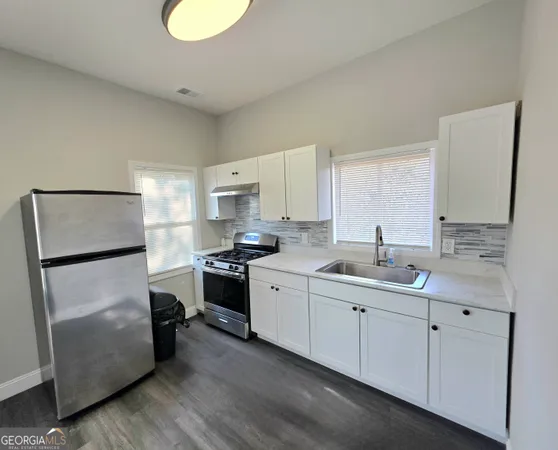 a kitchen with a sink appliances and cabinets