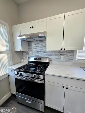 a stove top oven sitting inside of a kitchen