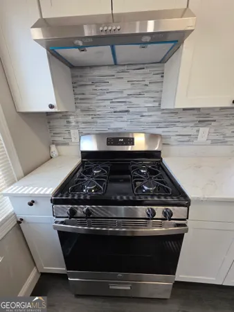 a stove top oven sitting inside of a kitchen
