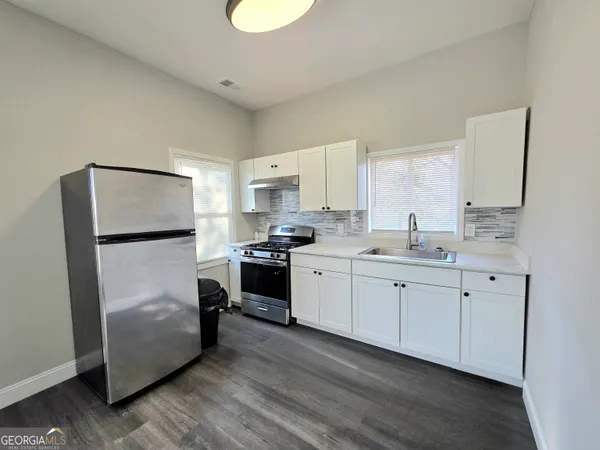 a kitchen with white cabinets and stainless steel appliances