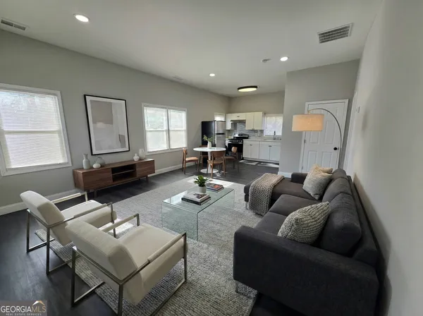 a living room with furniture and a wooden floor