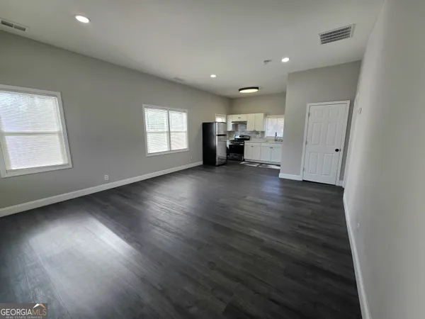an empty room with wooden floor and window