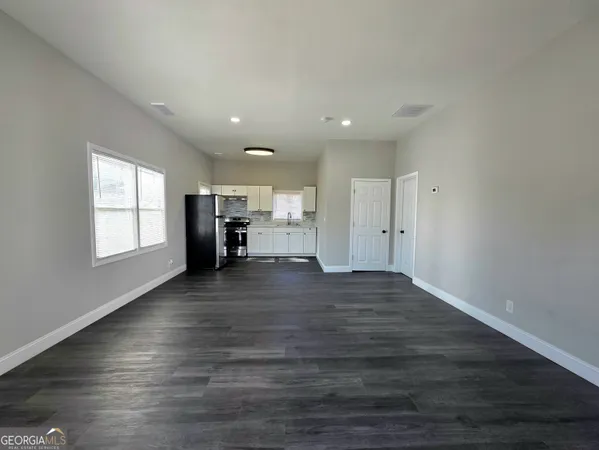 a view of empty room with wooden floor and window