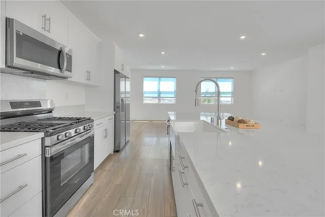 a kitchen with stainless steel appliances white cabinets and a stove top oven
