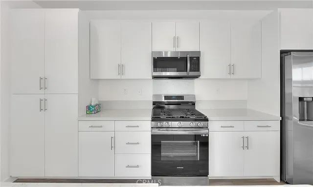 a view of a kitchen with a sink and wooden floor
