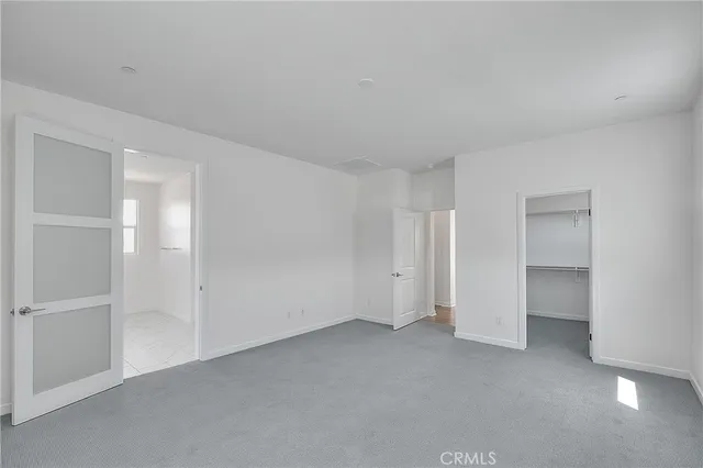 a view of an empty room with wooden floor and closet