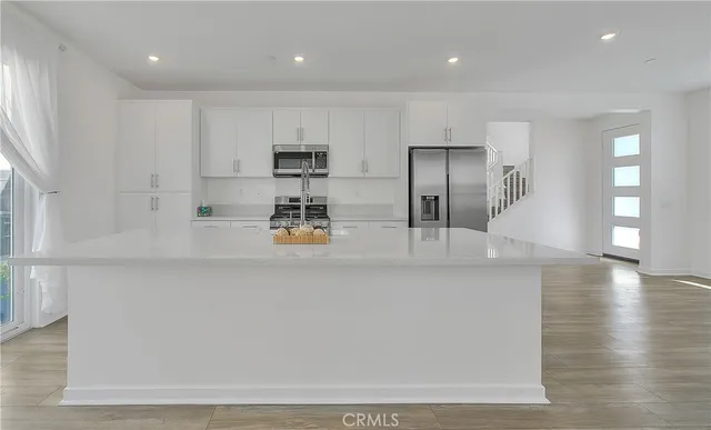 a kitchen with stainless steel appliances granite countertop a stove a sink and a wooden floors