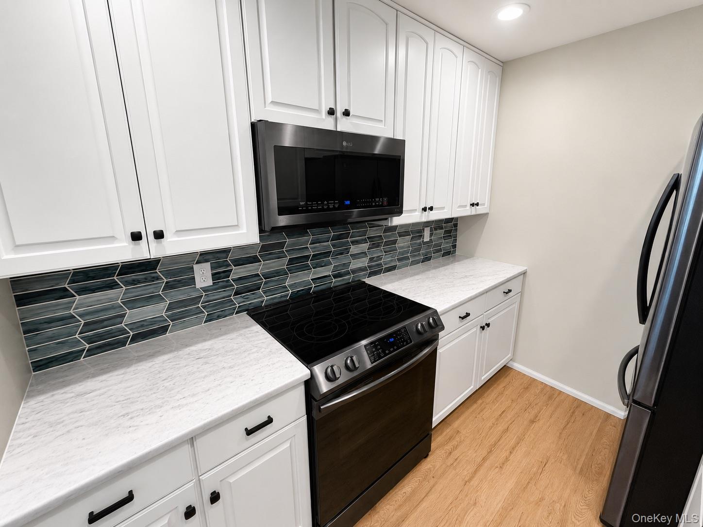 201 Birchwood Road, Unit 201 Coram, NY 11727 - Photo 6 of 27 a kitchen with granite countertop a stove and a microwave