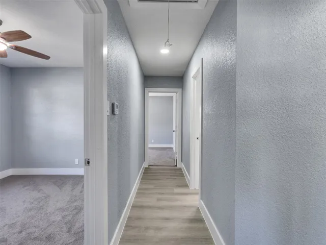 a view of a hallway with wooden floor
