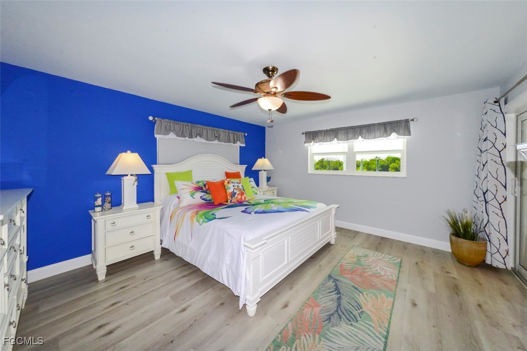 12082 Moon Shell Drive Matlacha Isles, FL 33991 - Photo 13 of 46 a bedroom with a bed and a chandelier