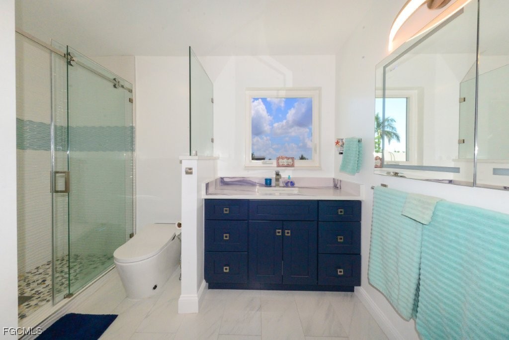 12082 Moon Shell Drive Matlacha Isles, FL 33991 - Photo 17 of 46 a bathroom with a double vanity sink mirror and toilet