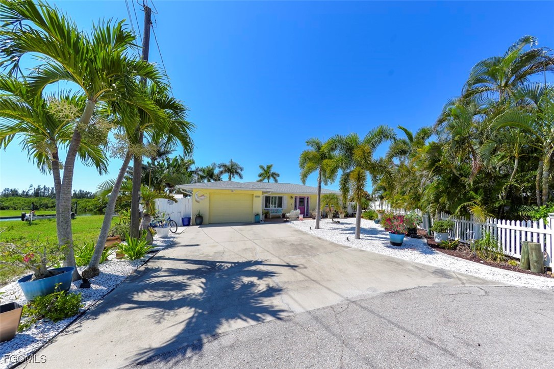 12082 Moon Shell Drive Matlacha Isles, FL 33991 - Photo 42 of 46 a row of palm trees in front of a house