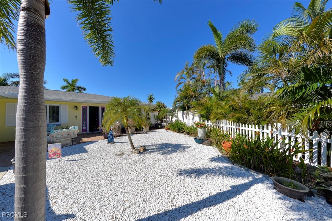 12082 Moon Shell Drive Matlacha Isles, FL 33991 - Photo 43 of 46 a vase of flowers sitting on a wooden floor