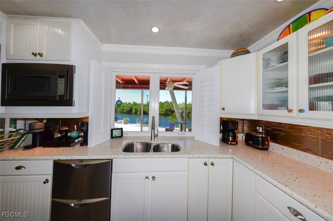 12082 Moon Shell Drive Matlacha Isles, FL 33991 - Photo 6 of 46 a kitchen with a stove a sink and a microwave