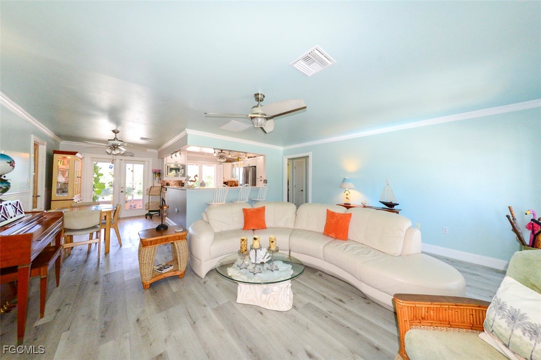 12082 Moon Shell Drive Matlacha Isles, FL 33991 - Photo 9 of 46 a living room with furniture and a dining table with wooden floor