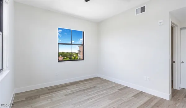 a view of a room with wooden floor and windows